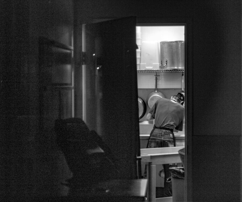 Chico limpiando cocina en blanco y negro